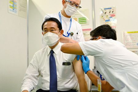 接受新型冠狀病毒疫苗第4劑的日本首相岸田文雄（前左）＝12日、東京都千代田區