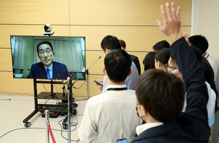 在首相公邸線上接受記者採訪的首相岸田文雄（監視器畫面）時舉手的記者們＝24日下午、首相官邸
