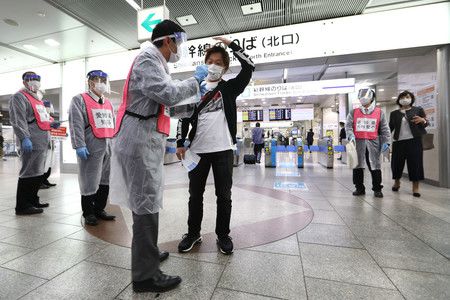 JR名古屋站新幹線剪票口外，工作人員測量旅客體溫。（29日上午，名古屋市中村區）