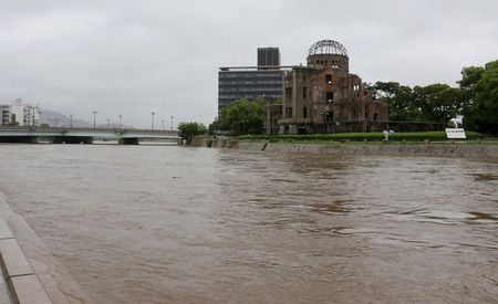 水位不斷上漲的廣島市元安川。右方為原爆紀念館＝19日下午、該市中區