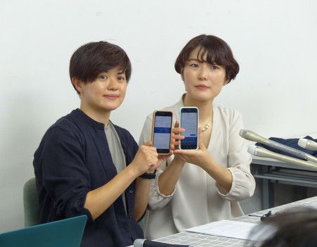 透過智慧型手機申請伴侶宣誓制度的山本Soyoka（左）與其伴侶＝11日午後、東京都新宿區