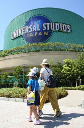 限制入場人數下，帶著孩子進入重新營業的大阪環球影城(USJ)的家長。(8日早上，大阪市此花區)