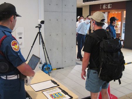 豐洲市場重新開放一般參觀後，在出入口處紅外線攝影機檢測溫度的男子。（6月8日、東京都江東區的豐洲市場）