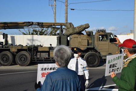 對新設陸上自衛隊石垣駐屯地進駐車輛表示反對的市民們＝5日上午、沖繩縣石垣市