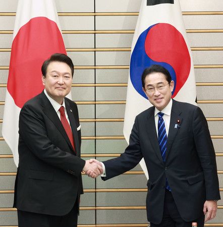 會談一開始、與韓國總統尹錫悅（左）握手的首相岸田文雄＝16日下午、首相官邸