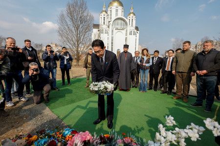 21日、造訪過去許多民眾遭到殺害的烏克蘭首都近郊布查、並獻花致意的首相岸田文雄（中央）（路透時事）