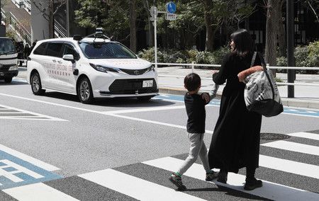 一輛自動駕駛汽車（左二）正在進行實驗。 遇到紅燈自動停止＝22日下午、東京都港區