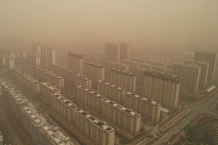 遭到大規模黃砂襲來的建築物＝11日、中國・山東省（AFP時事）