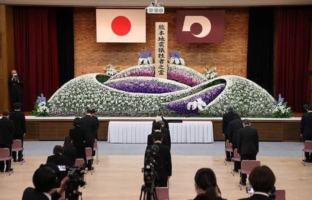 在熊本縣廳召開的熊本大地震罹難者追悼儀式上默禱的家屬們＝14日上午、熊本市