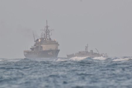 海上自衛隊艦艇，包括潛艇救助船千早號（左）在內，持續確認可能是飛機的機身附近海域進行搜索＝16日上午、沖繩縣宮古島市