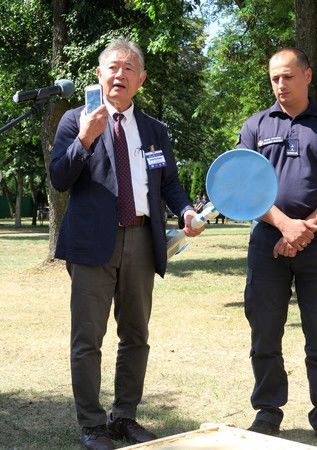說明地雷探測器的東北大學名譽教授佐藤源之（左）＝7日、華沙近郊