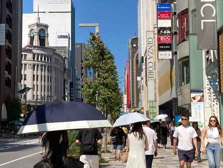 稱起陽傘漫步的人群＝5日下午、東京都中央區