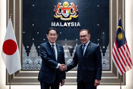 岸田首相在馬來西亞總理官邸與安瓦爾總理（右）握手＝5日、吉隆坡近郊（馬來西亞總理官邸提供・時事）