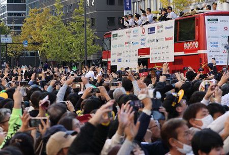 球迷們聚集在阪神虎勝利遊行隊伍中並向球員揮手＝23日下午、大阪市中央區