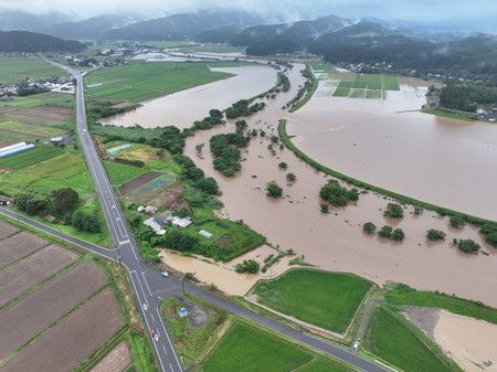 大雨影響下堤防崩壞的石澤川=25日上午、秋田縣由利本荘市(秋田縣河川砂防課提供)