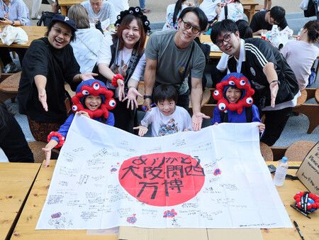 13日下午,大阪市此花區,大阪・關西世博會閉幕日,參觀者手持寫有感謝字句的旗幟,面帶笑容