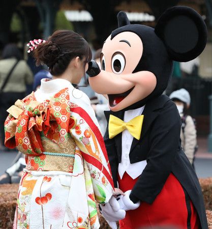 在東京迪士尼舉辦的成人儀式中，與穿著和服的新成人打招呼的米奇老鼠＝2018年1月、千葉縣浦安市
