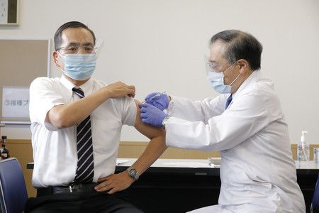 日本國內首個接種新型冠狀病毒疫苗的國立醫院機構東京醫療中心的院長新木一弘（左）＝17日上午、東京都目黒區