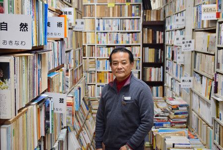 被沖繩中古書圍繞的中古書店「BOOKS JINON」店長天久齊，他稱店是「可買的圖書館、可買的資料館」＝2月19日、沖繩縣宜野灣市