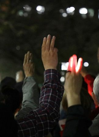 在外務省前舉起象徵民主化3根手指的在日緬甸人＝1日下午、於東京都千代田區
