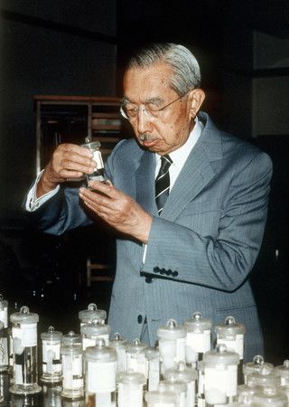 在皇居生物學研究所手持標本端詳的昭和天皇＝1986年