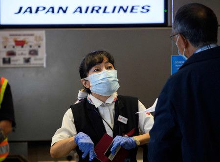 在美國加州洛杉磯機場幫助乘客辦理登機手續的日本航空職員＝2020年11月（AFP時事）