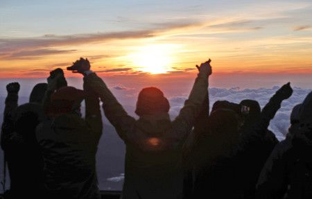 2018年的開山早晨，來富士山頂迎接日出高喊萬歲的登山者們＝該年7月1日