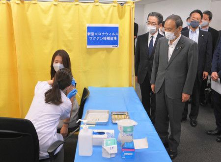 視察全日空機組員進行新型冠狀病毒疫苗職場施打的菅義偉首相（右手前方）＝28日上午、羽田機場（媒體代表攝影）
