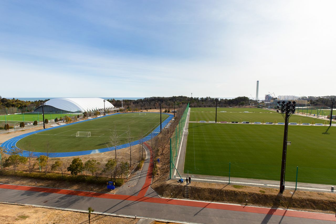 ホテル棟の展望室からピッチを眺める。右の3面は天然芝、陸上トラックの内側は人工芝のピッチ。左奥にある全天候型サッカー練習場の向こうに太平洋が見える