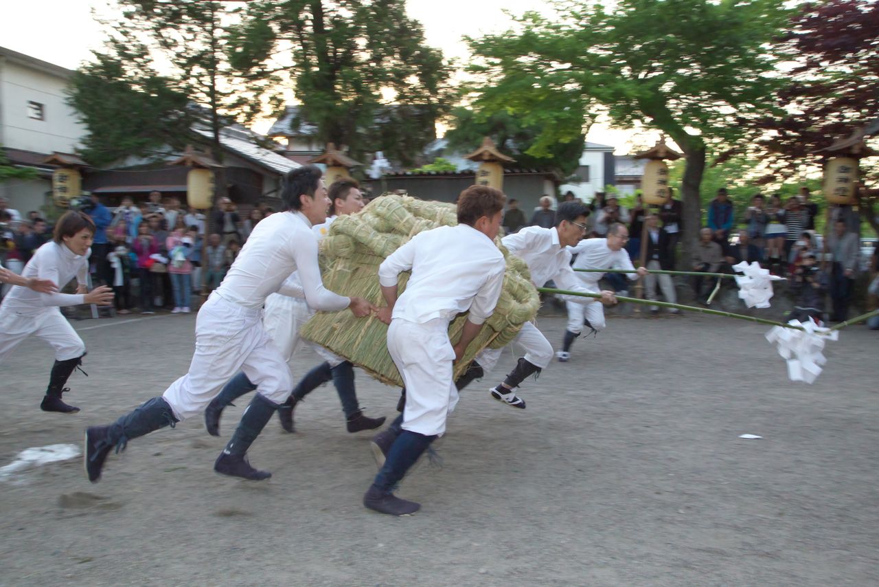 東西対抗のお供え競走。わら製の供物は保護役と呼ぶ年長の氏子が作る