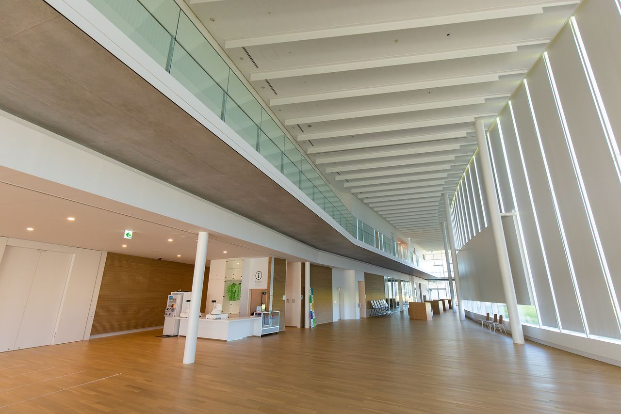 木材を印象的に使用した明るいロビー。地上3階建てで、総床面積は5256平方メートル