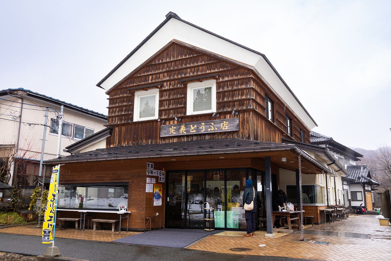 店頭のテーブル席で、アツアツの三角定義油揚げが堪能できる定義とうふ店(撮影:ニッポンドットコム編集部)