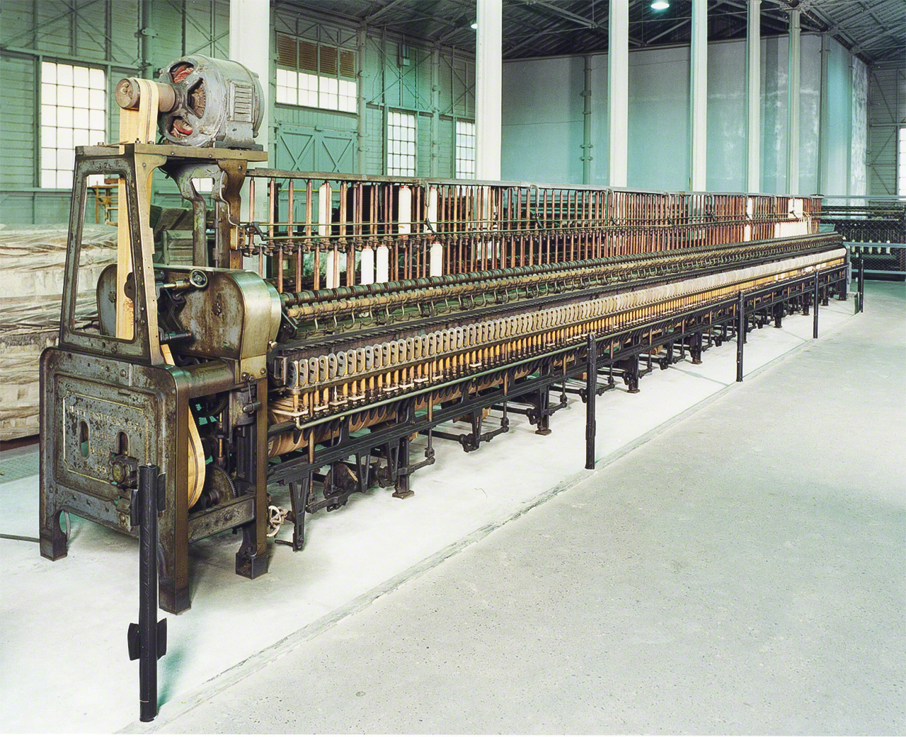 英国プラット社製のリング精紡機。紡績機とは、粗糸に撚（よ）りをかけて紡ぐ機械