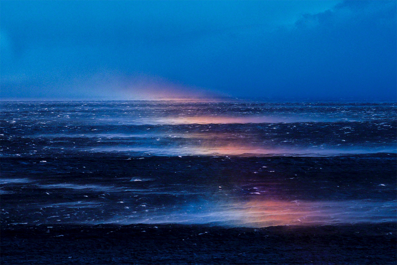 波しぶきが強風にあおられて虹が立つ（オホーツク海）