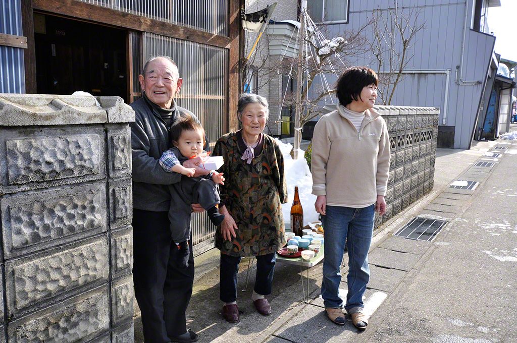 「川を渡る梵天」の日。若衆に酒をふるまう一家。(秋田県大仙市)