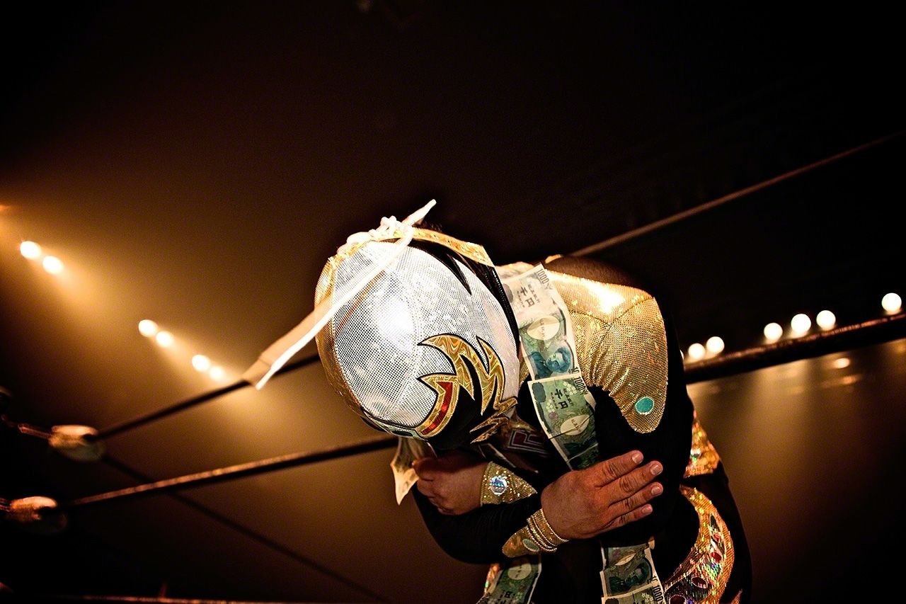 千円札の首飾りをかけ、日本の観客に挨拶するマスカリータ・ドラーダ(黄金仮面)。Zepp 東京。2009年3月20日