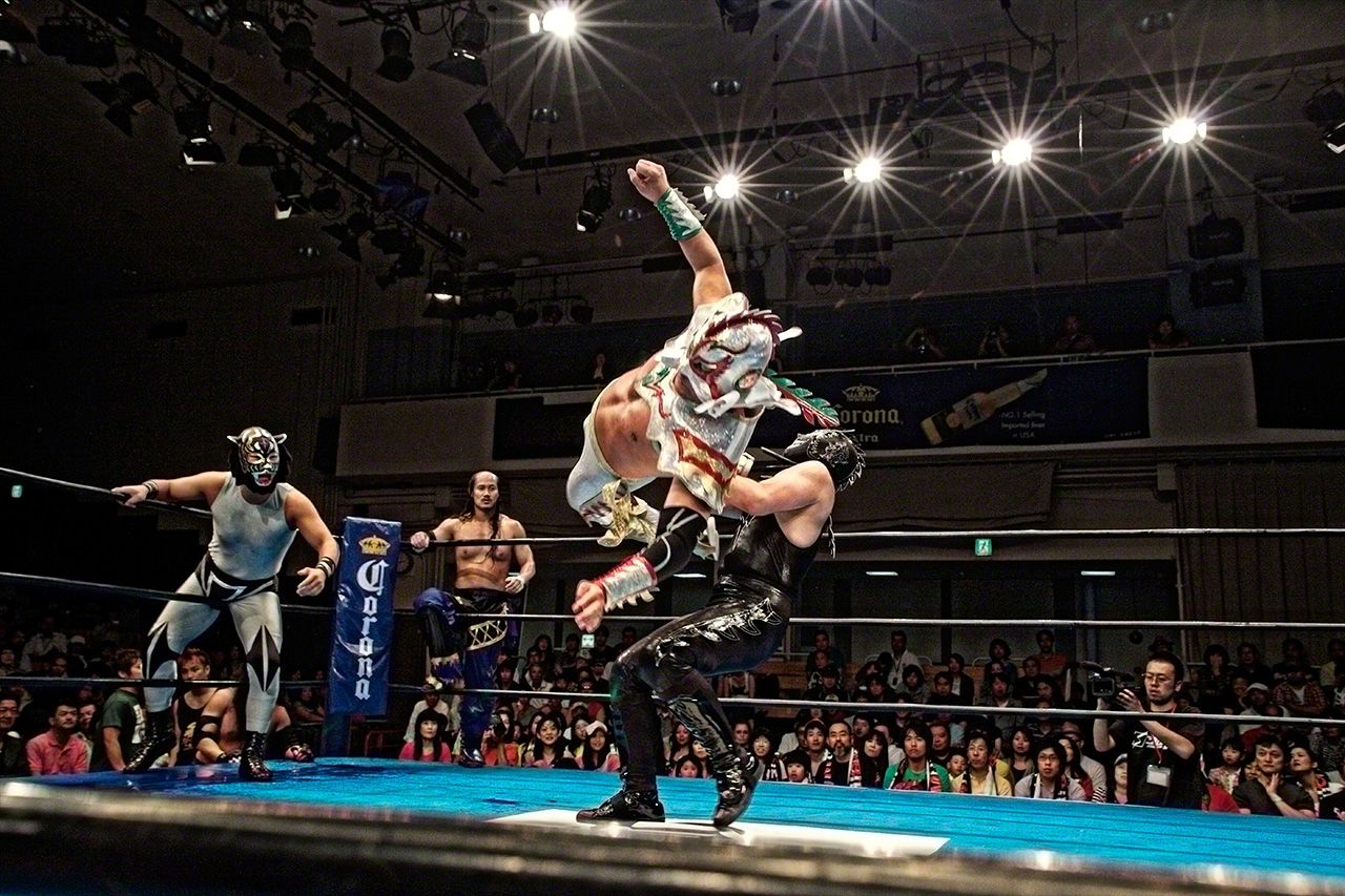 ドラゴン・ネグロ(黒いドラゴン)の胸を足蹴りするウルティモ・ドラゴン(最後のドラゴン)。後楽園ホール。2010年