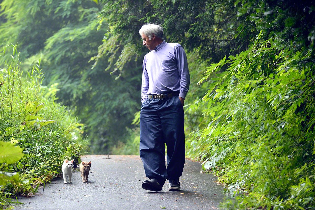 牛の餌やりが終わった午後、松村さんと散歩に出掛けるしろとさび。松村さんは一見コワモテだが、動物たちに無償の愛情を注ぐ心優しきおじさんだ。ほとんどいつも作業着を着ている。
