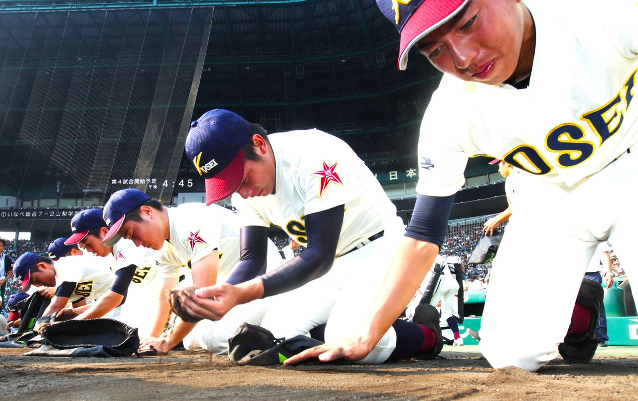 2016年夏の甲子園大会、2回戦で東邦(愛知)にサヨナラ負けし、涙をこらえてグラウンドの砂を集める八戸学院光星(青森)ナイン 時事