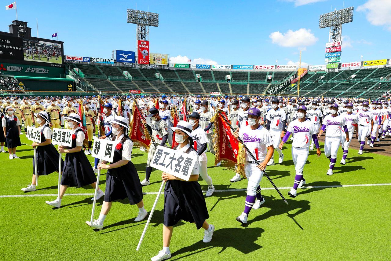 コロナ下で開催された第103回全国高校野球選手権大会の開会式で、元気いっぱい行進する各校の選手たち(2021年8月10日)時事