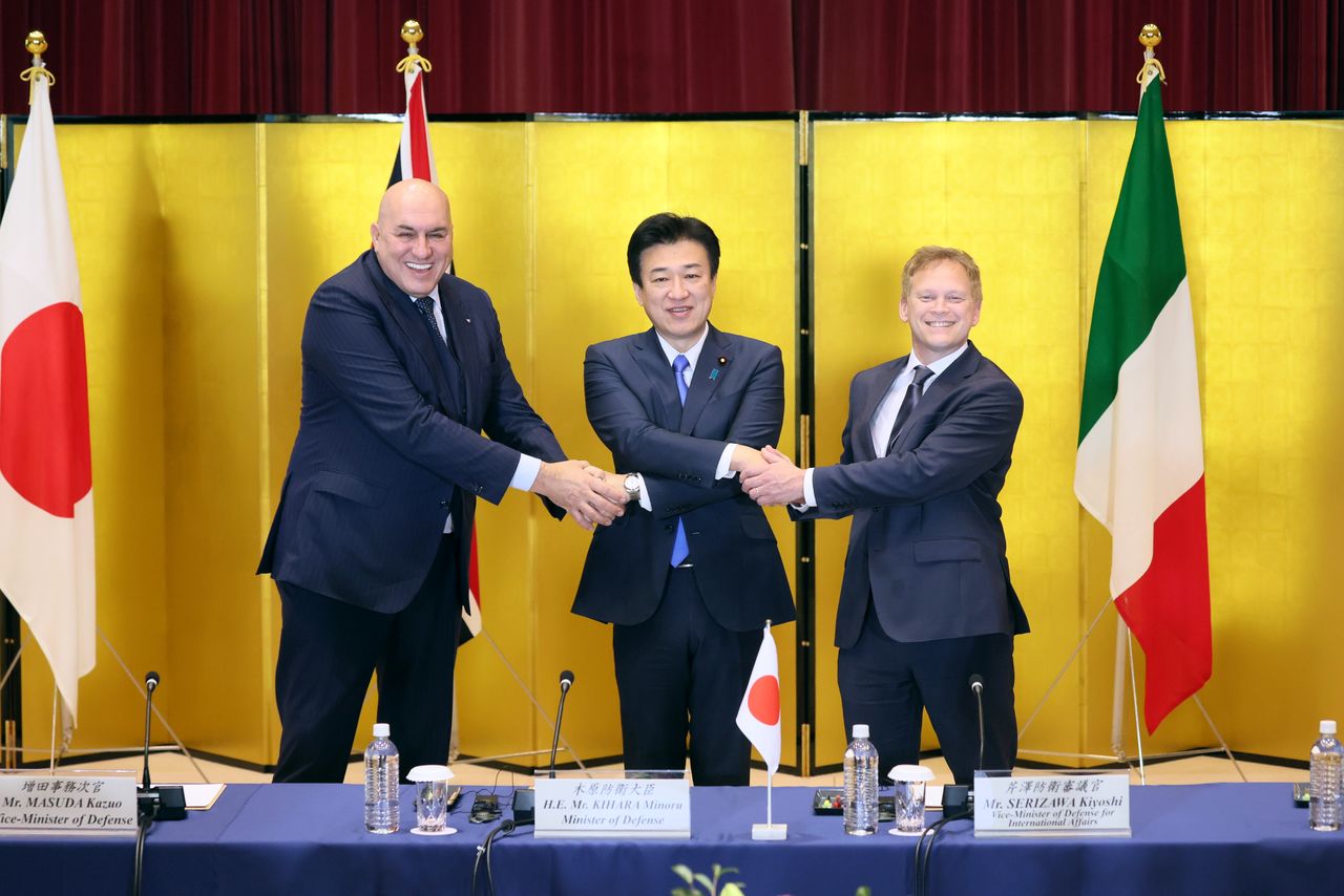 英国のシャップス国防相(右)、イタリアのクロセット国防相(左)と握手する木原稔防衛相=2023年12月14日、東京都新宿区の防衛省で(時事)