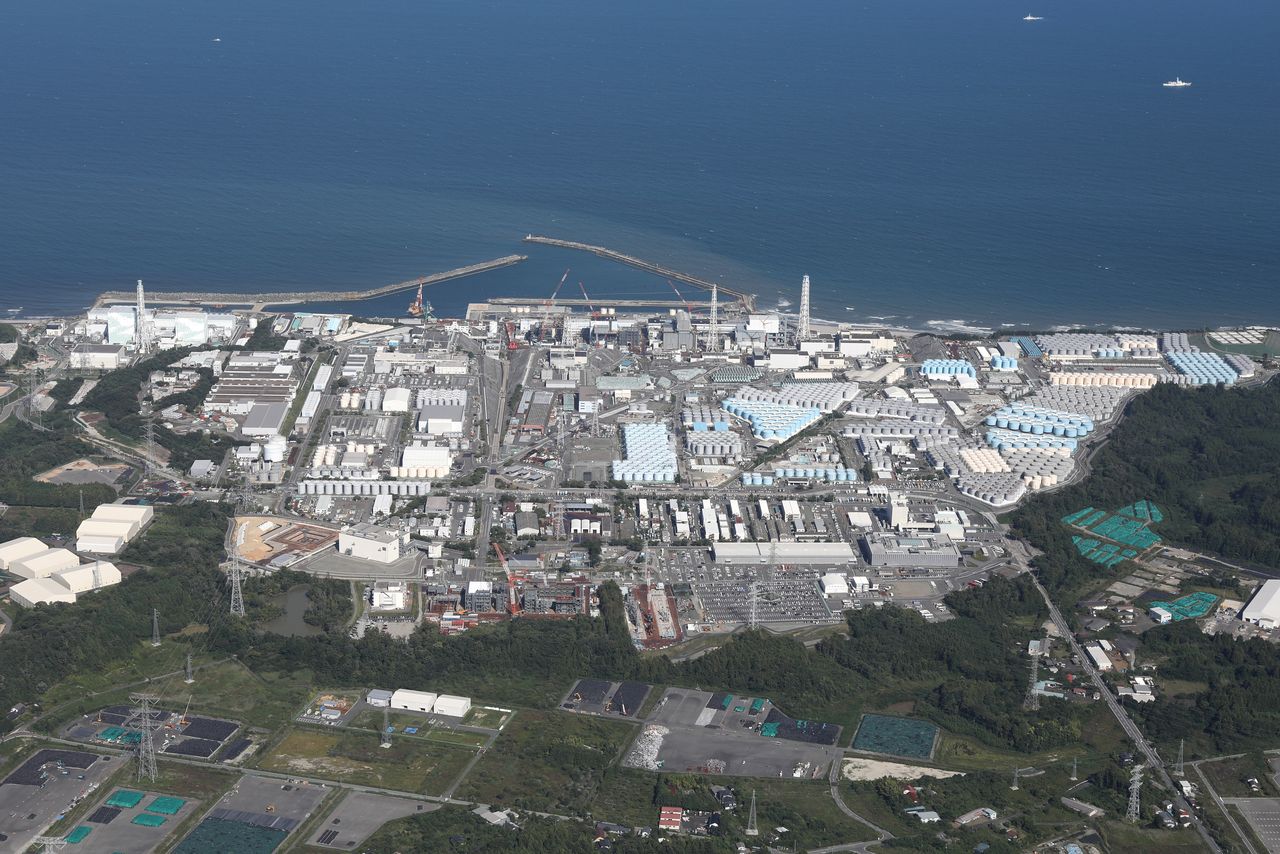 東京電力福島第1原子力発電所。画面向かって右側は、処理水のタンクで埋め尽くされている(2023年8月24日撮影、時事)