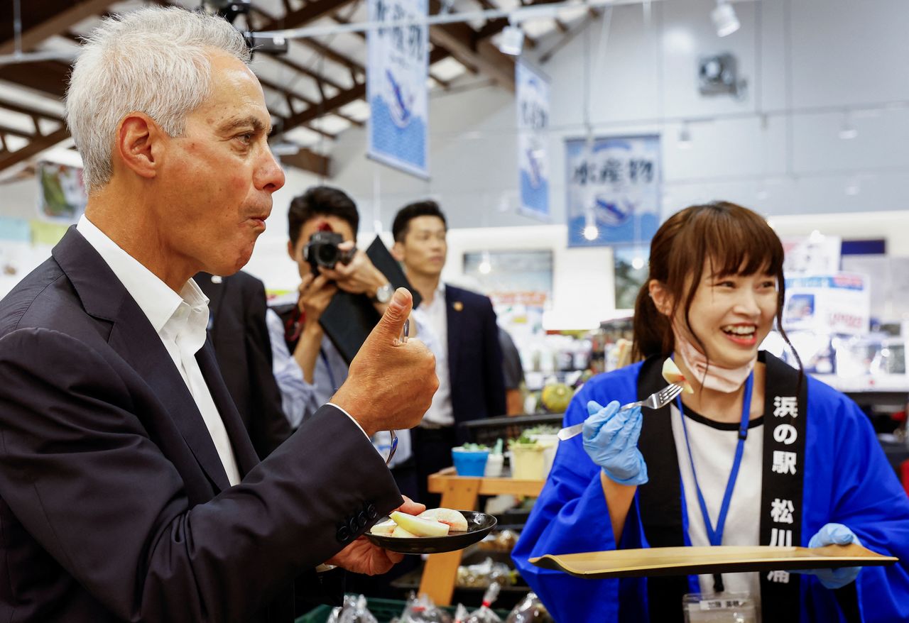 最初の海洋放出のさなか、福島県相馬市を訪れたエマニュエル駐日米大使。地元の産品を扱う「浜の駅松川浦」では果物を試食したり、水産物を購入したりした(2023年8月31日、ロイター)