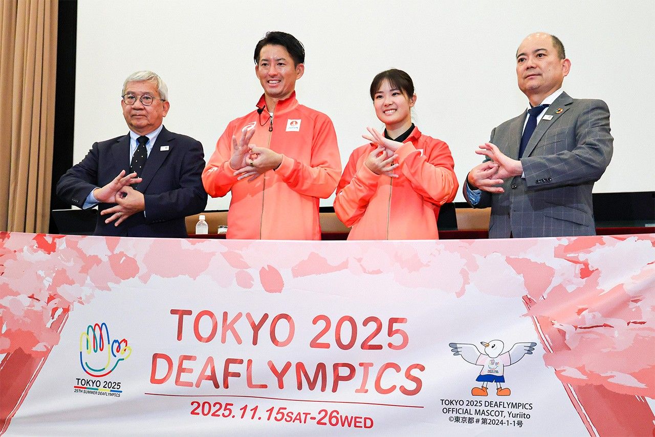 デフリンピック東京大会の記者会見でポーズを取る(左から)日本選手団の太田陽介団長、旗手を務めるサッカー男子主将の松元卓巳選手と空手女子の小倉涼選手、全日本ろうあ連盟の石橋大吾理事長=2025年10月16日、東京都内(時事)