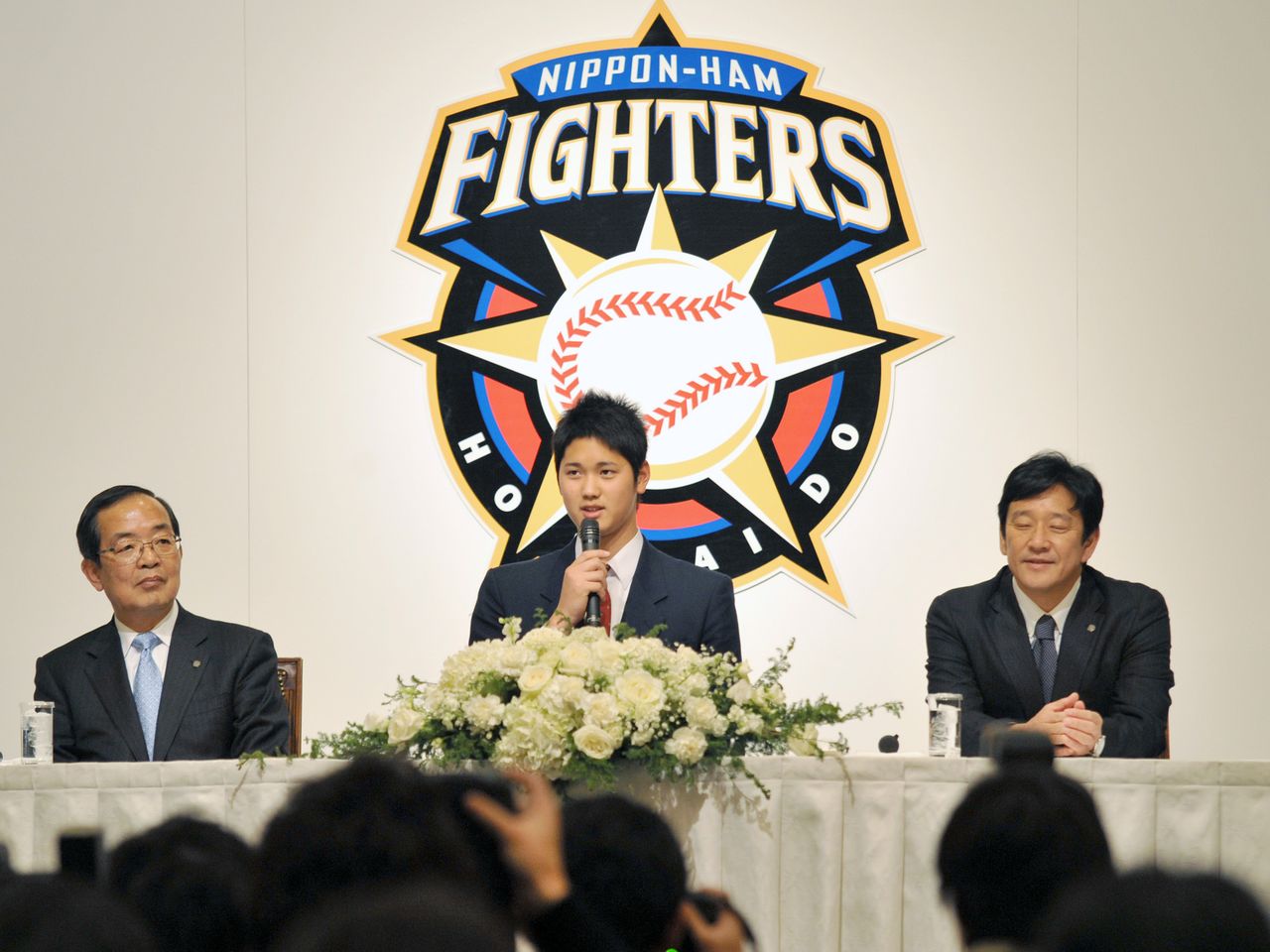 日本ハムの入団記者会見で、質問に答える岩手・花巻東高の大谷翔平投手(中央)。右は栗山英樹監督、左は津田敏一球団社長=2012年12月25日、北海道・札幌市内のホテル(時事)