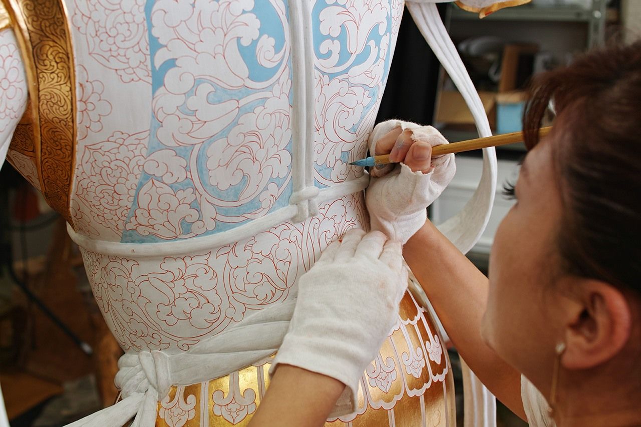 繧繝彩色(うんげんさいしき)は、濃さの異なる色が数段に分かれているが、濃い色は白下地にいきなり塗るのではなく、例えば濃い青の下には「やや濃い青」「普通の青」「やや白っぽい青」「かなり白っぽい青」がすべて隠れている。一番下にある「かなり白っぽい青」を塗っている様子。写真=小島 久典(藝大)