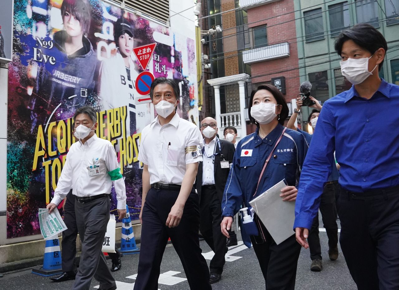 歌舞伎町のホストクラブなどに新型コロナウイルス対策を呼び掛けに回る新宿区の吉住健一区長（左から2人目）ら＝2020年7月20日、東京都新宿区（時事）