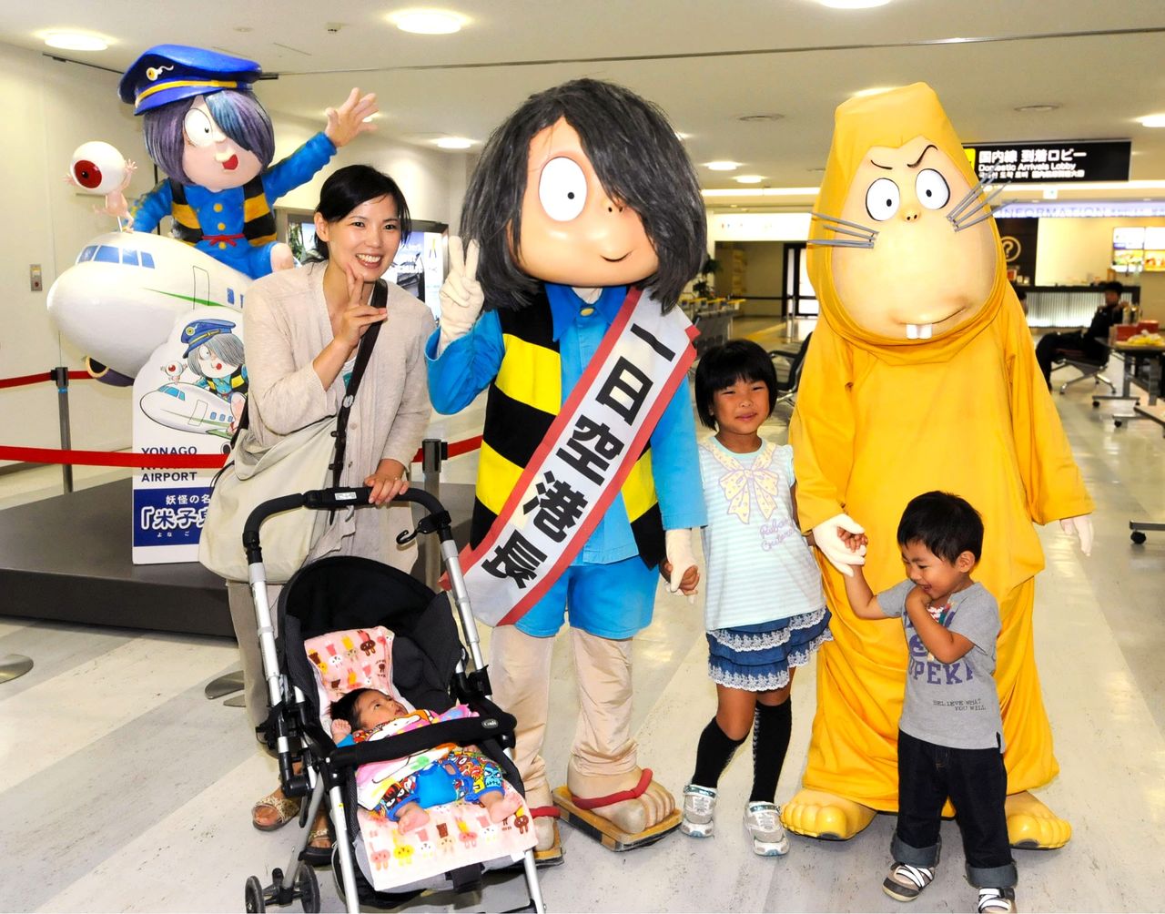 米子鬼太郎空港の一日空港長に任命され、子どもたちと記念撮影する「鬼太郎」(中央左)=2013年9月28日、鳥取県境港市(共同)