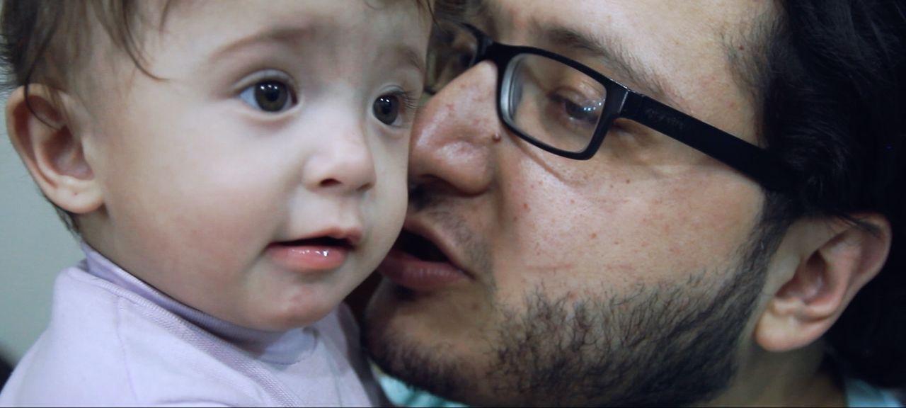 ワアドとの間に生まれた愛娘サマを抱くハムザ　© Channel 4 Television Corporation MMXIX