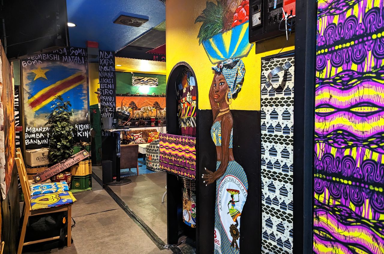 店内の絵や装飾はほとんどが舞さんの手によるもの。女性の衣装にはコンゴの布が使われている 写真:熊崎敬